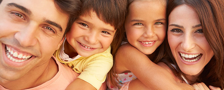 a young couple with kids smiling