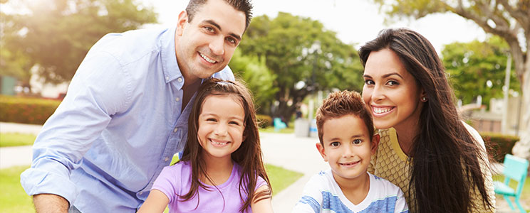 a young family in a park smiling